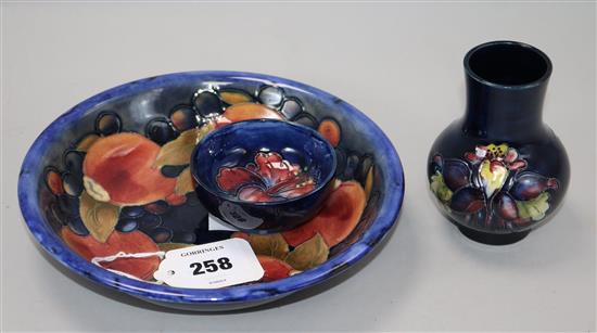 A Moorcroft pomegranate pattern dish, a tiger lily pattern small vase and a hibiscus pattern dish, 8cm - 20.5cm